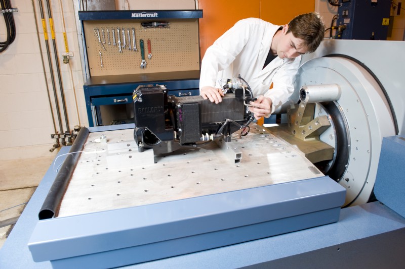 A technician inspects a fuel cell undergoing vibration tests on a R16 shaker